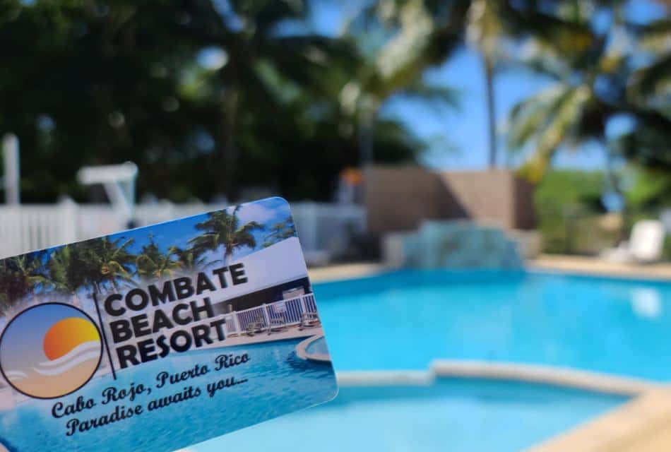 Close up view of Combate Beach Resort gift card with view of pool in the background
